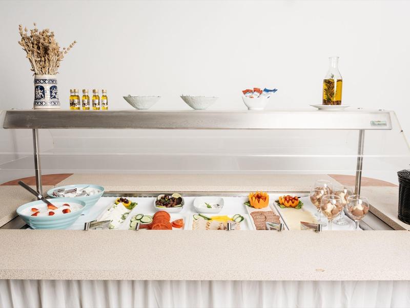 Bufet samoobsługowy z różnymi zimnymi przystawkami i sałatkami w miseczkach i na talerzach