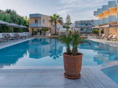 Nowoczesny basen hotelowy z leżakami i parasolami w spokojnym otoczeniu.