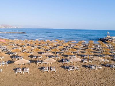 Strand mit vielen Sonnenschirmen und Liegestühlen am Meer an einem sonnigen Tag