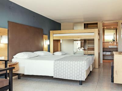 světlý rodinný pokoj s manželskou postelí, palandou a moderním vybavením.