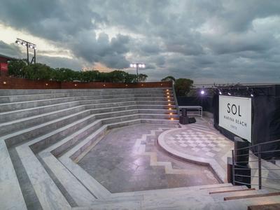 Anfiteatro all'aperto con gradini e palco sotto un cielo nuvoloso in un ambiente alberghiero