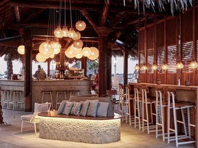 Gezellig buitenbar met ronde zitplaatsen en moderne hanglampen in houtlook.