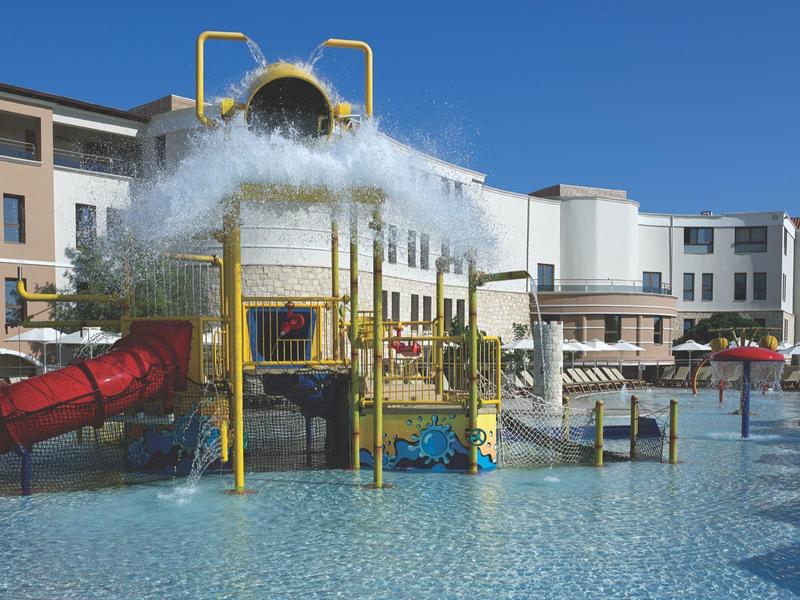 Waterpark met speeltoestellen en waterkanonnen in een hotelzwembad bij heldere lucht