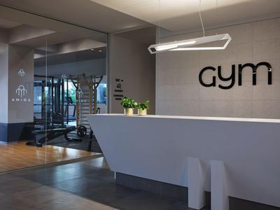 Moderne receptie van de sportschool met minimalistische balie en verlicht 'gym'-bord.