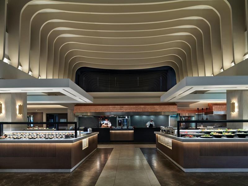 Restaurant d'hôtel moderne avec un design élégant et des arches de plafond courbées.