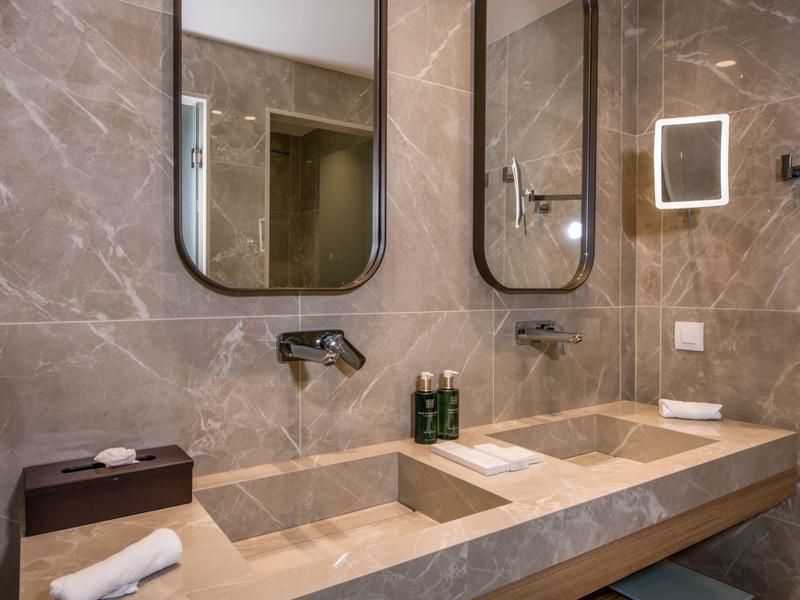 Espace bar d'hôtel moderne avec décoration en bois ondulé et tabourets hauts.