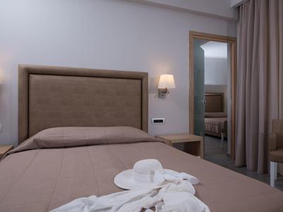 Schlafzimmer mit braunem Bett, Kopfteil, zwei Wandleuchten und Spiegel an der Wand.