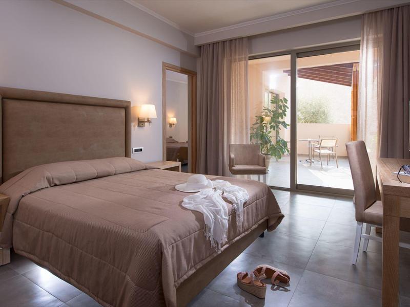 Chambre d'hôtel confortable avec lit double, bureau, TV et balcon.