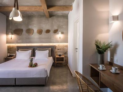 Habitación de hotel moderna con cama doble, techo de madera e iluminación acogedora.