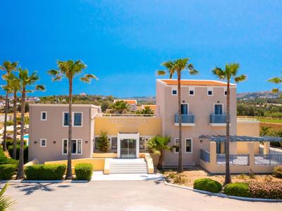 Nowoczesny budynek hotelowy z palmami i czystym, niebieskim niebem w tle.