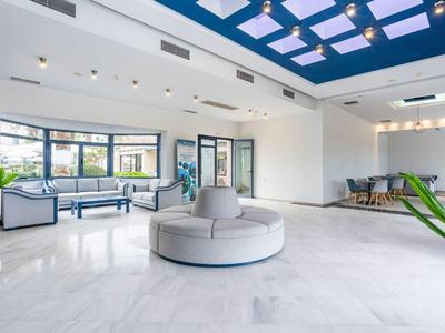 Jasne, nowoczesne lobby hotelowe z miejscami do siedzenia i dużymi oknami.