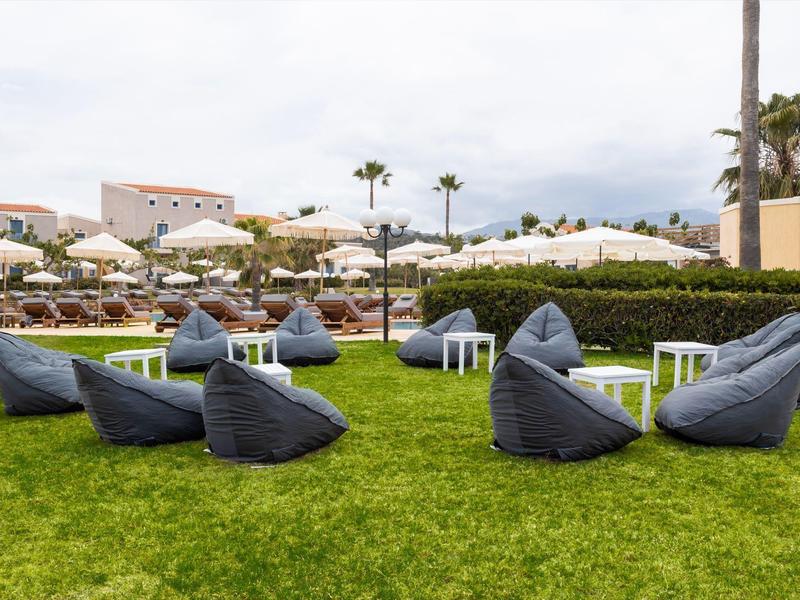 Wygodne siedzenia na trawie z parasolami w tle.