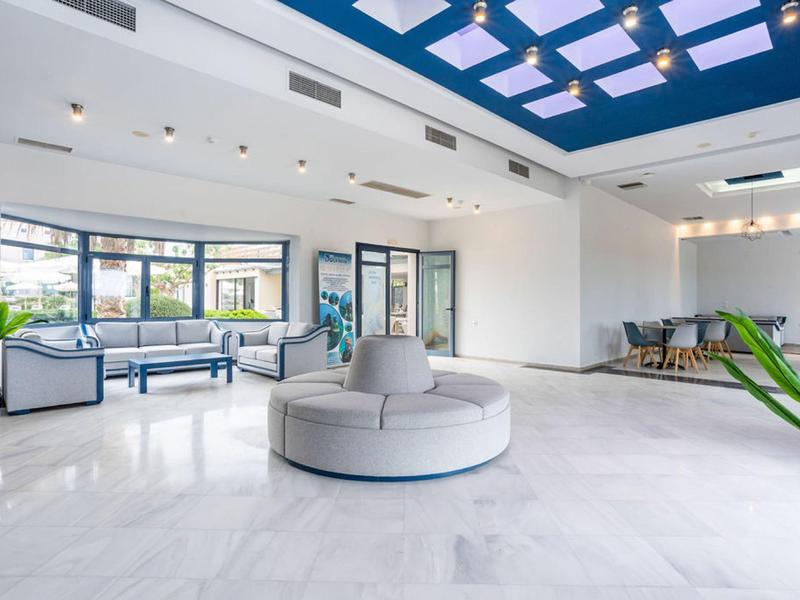 Jasne, nowoczesne lobby hotelowe z miejscami do siedzenia i dużymi oknami.