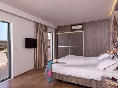 Modernes Hotelzimmer mit Doppelbett, Balkon und Blick auf den Innenhof.