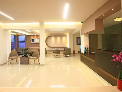 Helle, moderne Hotellobby mit Sitzbereichen und elegantem Empfangstresen.