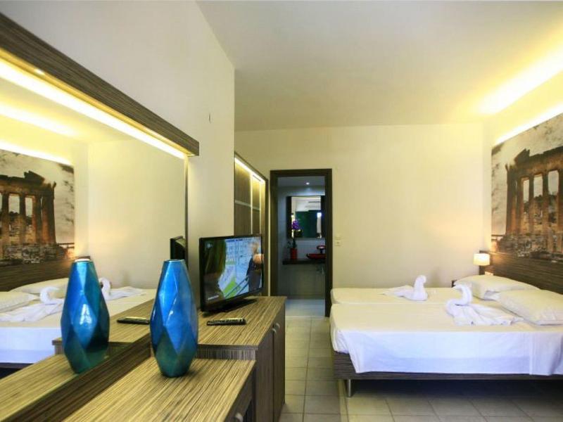 Modernes Hotelzimmer mit Doppelbett, großem Spiegel und Wandbild eines antiken Tempels.