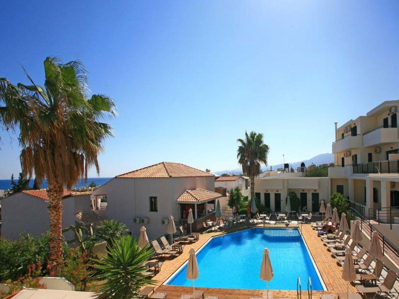 Hotelpool mit Liegestühlen, Palmen und klarem blauem Himmel in einer sonnigen Umgebung.