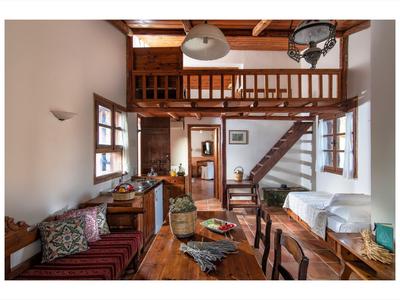 Przytulny rustykalny salon z drewnianymi meblami i otwartą galerią ze schodami