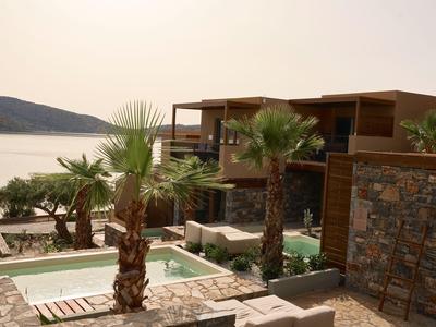 Moderne Ferienwohnungen mit Pool und Blick auf das Meer und die umliegende Landschaft.