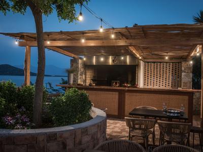 Abendliche Barterrasse mit Lichterkette und Blick auf das Meer bei Dämmerung