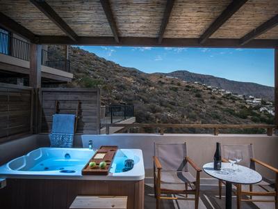 Überdachte Terrasse mit Whirlpool, Tisch und Stühlen mit Bergblick bei Dämmerung