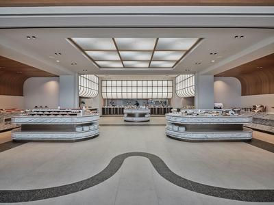 Modern, spacious buffet area with bright counters and indirect lighting in a hotel.