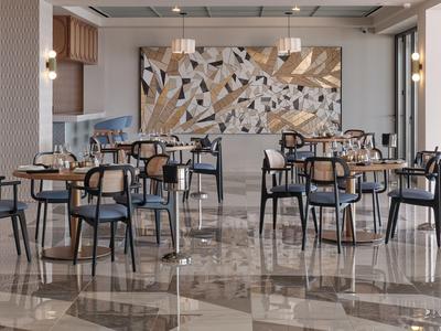Moderne lege eetzaal met zwarte stoelen en patroonmotief aan de muur in een hotel.