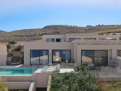 Modern holiday home with large pool and terrace in a hilly landscape.