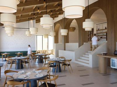 Bright restaurant with wooden beam ceiling, round tables, large lamps, and an open buffet area.