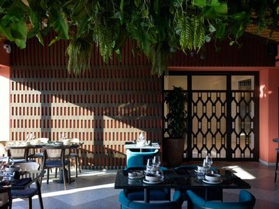 Modern lounge area with blue chairs, stylish tables, and vertical wooden wall elements.