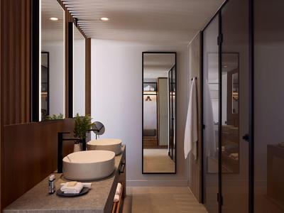 Modern hotel bathroom with sink, large mirror, and wardrobe in the background.