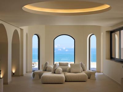 Modern furnished room with sofas and window view of the sea.