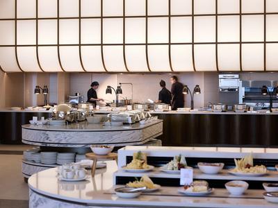 Modern buffet with various dishes and bright, curved lighting element.