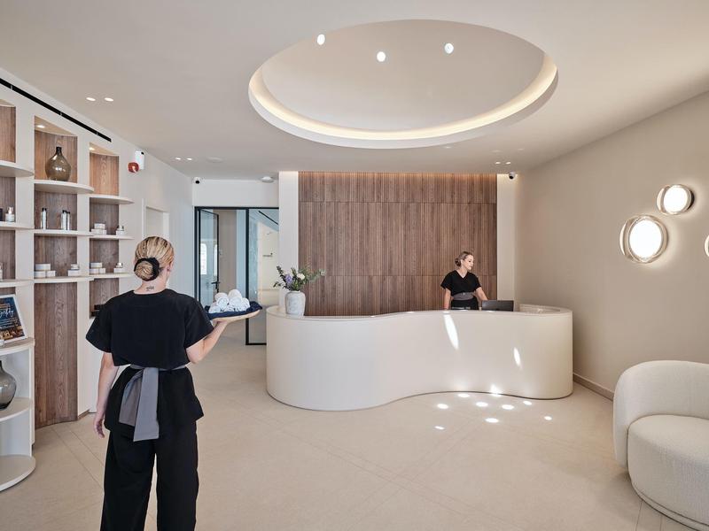 Bright hotel reception with modern desk and two staff in a stylish setting.