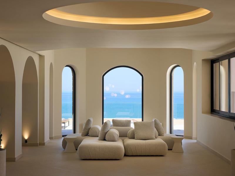 Modern furnished room with sofas and window view of the sea.