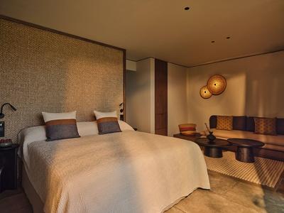 Gemütliches Hotelzimmer mit großem Bett, gedämpfter Beleuchtung und stilvoller Wanddekoration.