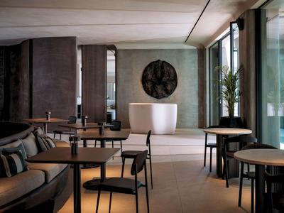 Modernes Café mit Tischen, Stühlen und gemütlichen Sitzgelegenheiten bei Tageslicht.