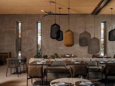 Gemütlicher Speisesaal mit moderner Beleuchtung und schlichter Einrichtung in warmen Tönen.