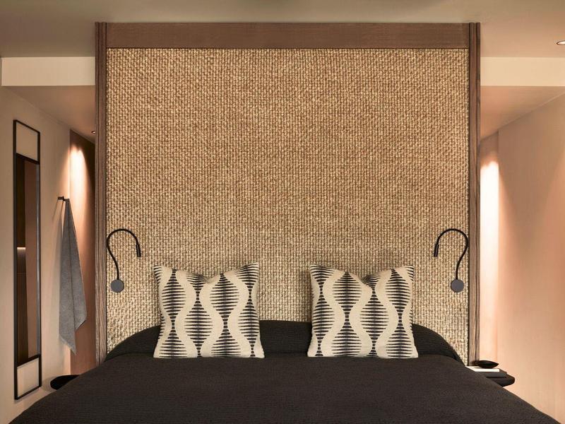 Moderne slaapkamer met tweepersoonsbed, sierkussens en warm licht