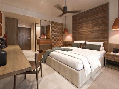 Modern hotel room with large bed, desk, and warm wooden accents.