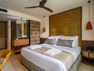 Habitación de hotel moderna con cama grande, acentos de madera y luz acogedora.