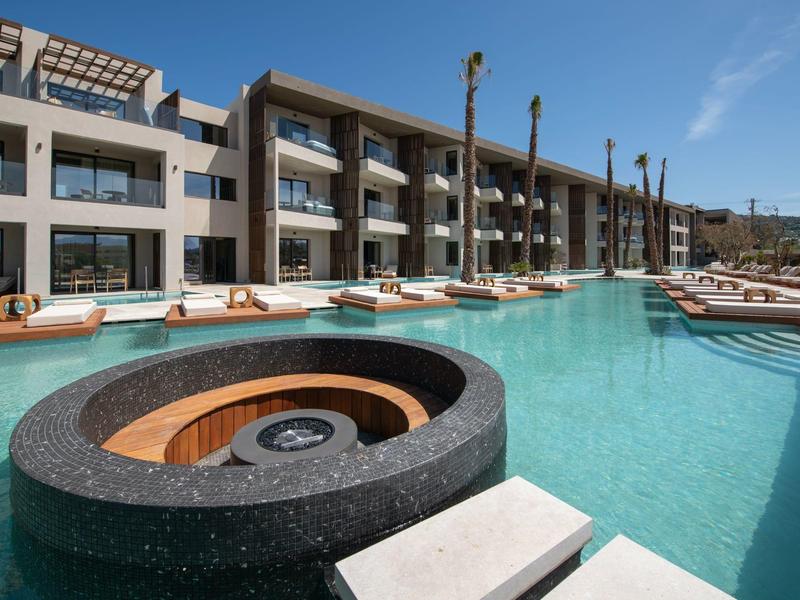 Moderní bazén s vestavěnou vířivkou před hotelem s moderním designem.