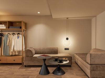 Gemütliche Hotellounge mit zwei Sofas, Holzboden und moderner Beleuchtung.