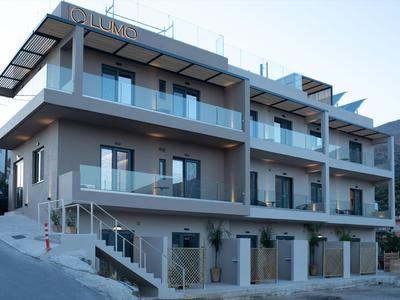 Nowoczesny, wielopiętrowy hotel z balkonami i szklanymi balustradami przy stromej ulicy.