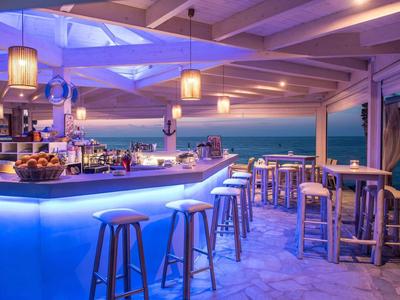 Moderne bar met blauwe verlichting en zeezicht bij zonsondergang