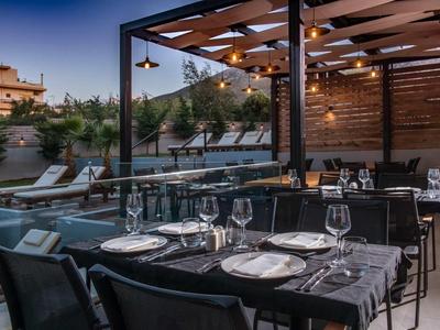 Ristorante elegante all'aperto con tavoli apparecchiati e area lounge al crepuscolo.