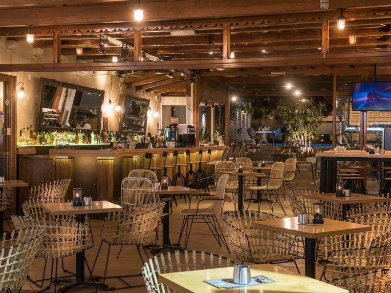 Bar dell'hotel accogliente con sedie in vimini moderne e illuminazione calda