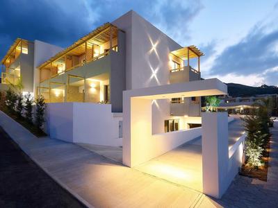 Edificio moderno di un hotel con illuminazione al crepuscolo e cielo sereno.