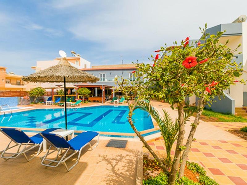 Einladender Poolbereich mit blauen Liegestühlen, Sonnenschirm und blühendem Hibiskus im Garten.