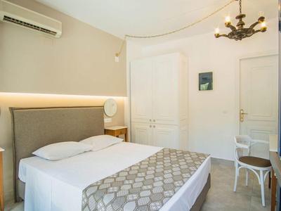 Modern bright hotel room with double bed, gray headboard, and small desk.